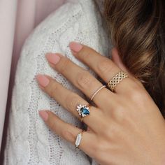 a woman's hand with two rings on her finger and one ring in the other