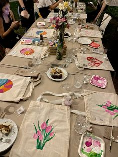 a long table with plates and napkins on it, decorated with flowers and hearts