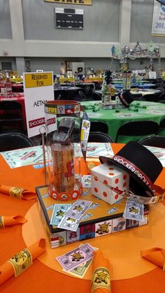 an orange table topped with lots of cards and other items at a convention or show