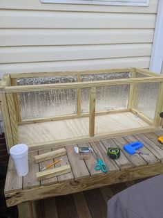 a bench made out of pallet wood with tools on the table and cup next to it