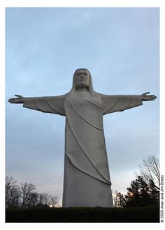 the statue of jesus is in front of some trees