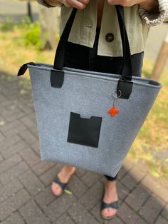 a woman holding a gray and black bag