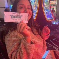 a woman is holding up a ticket to play the video game cashout volder