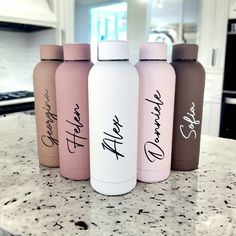 four water bottles sitting on top of a kitchen counter