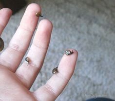 a person's left hand with tiny nails on it and two other nail tips sticking out of the palm