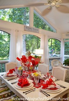 a dining room table set with red and white dishes