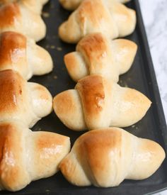 rolls are lined up on a baking sheet and ready to be baked in the oven