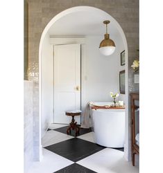 an arched doorway leads into a bathroom with black and white checkered flooring on the walls