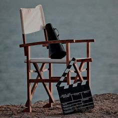 a director's chair with a movie clapper and a black megaphone sitting on top of it