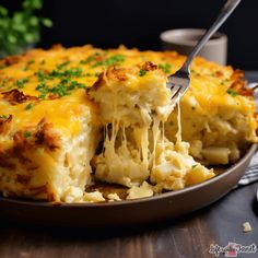 a fork is being lifted out of a cheesy casserole with cheese