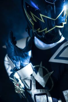 a close up of a person wearing a helmet and holding something in his hand with both hands