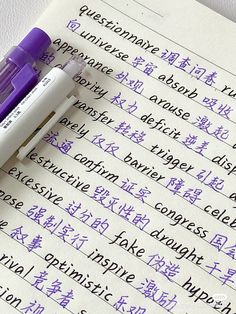 a purple pen sitting on top of a piece of paper with writing in english and chinese