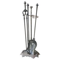 an iron fireplace tool holder with three different types of tools on it's stand