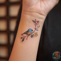 a small wrist tattoo with a bird on it