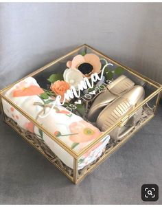 an open box with shoes and flowers on it