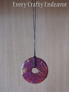 a pink donut hanging from a string on a wooden wall with the words every crafty endeavor above it