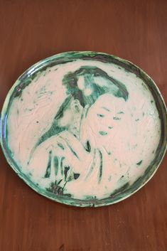 a green and white plate sitting on top of a wooden table