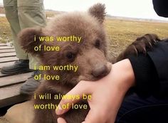 a person holding a small brown bear in their hand with the caption i was worthy of love