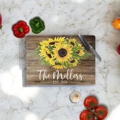 a cutting board with sunflowers and tomatoes on it