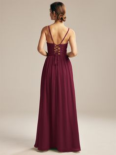 the back of a woman wearing a long dress with straps and laces on it