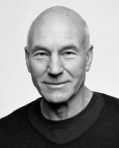 black and white photo of an older man smiling at the camera with his eyes closed