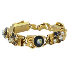 This is a 1960s Kramer of NY bracelet with Fleur de Lis. It has six linked detailed 3D design gold tone metal block sections and a fold-over clasp. Alternating sections are decorated with fleur di lis and round black enamel button shape with prong set AB rhinstones on top. Kramer of NY, a well-respected name and collected costume jewelry line. Louis Kramer founded the company in 1943. Our vintage jewelry collection and original creations are all unique listings. We never have multiple copies of anything. So, if you miss the current opportunity you may not get another chance to own the piece you love. It usually takes us one day to ship out orders excepting weekends. We have 20 years of online business and shipping experience. We have quite different inventory for our physical store and onl Rose Gold Fashion, Gold Link Bracelet, Rhinestone Bracelet, Pink Bracelet, Diamond Bracelets, Belle Epoque, Clear Rhinestones, Black Enamel, Gold Tone Metal