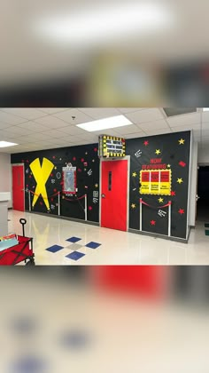 an empty school hallway with red doors and yellow firetrucks on the wall