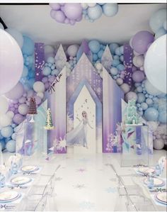 a frozen princess birthday party with balloons, cake and table settings in front of the backdrop