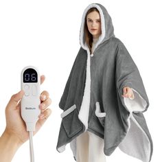 a person is holding a thermometer in front of a hooded jacket that has an alarm clock on it