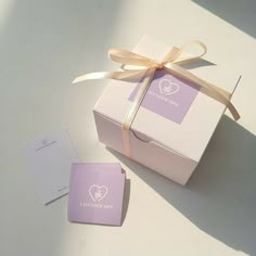 a pink box with a bow and some cards