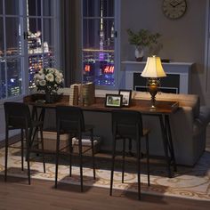 a living room filled with furniture and a large window covered in night time city lights