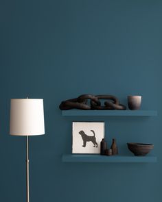 a living room with blue walls and shelves filled with decorative items on the wall, along with a dog figurine