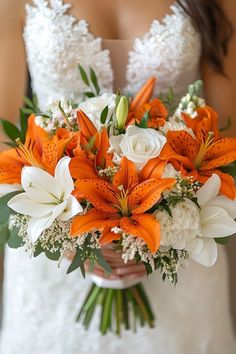 a bride holding a bouquet of orange and white flowers