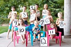 a group of children sitting around each other with numbers on them