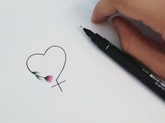 someone is drawing a heart with a flower on paper