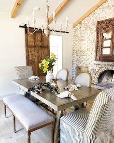 a dining room table and chairs in front of a fireplace