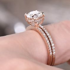 a woman's hand with a rose gold ring and diamond wedding band on it