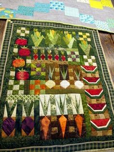 a quilted table runner with many different designs on it, including tulips and other flowers