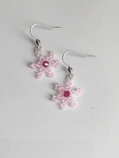 Little pink snowflakes made out of Miyuki glass beads with a Swarovski crystal bead in the centre for a bit of extra sparkle.  Hung on 302 stainless steel ear wires. Pink Sparkling Crystal Earrings Gift, Pink Sparkling Crystal Earrings For Gift, Pink Beaded Dangle Earrings With Bead Caps, Pink Dangle Beaded Earrings With Bead Caps, Pink Beaded Earrings With Bead Caps As Gift, Handmade Pink Crystal Earrings, Snowflake Earrings, Swarovski Crystal Beads, Earrings Pink