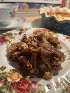 a close up of a plate of food on a table with a cup and saucer