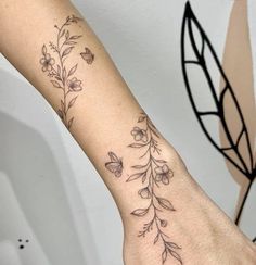 a woman's arm with flowers and butterflies on it