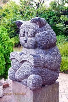 a statue of a bear sitting on top of a stone block