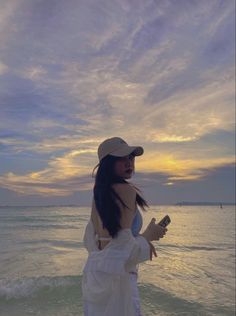 a woman standing on top of a beach next to the ocean