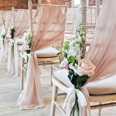 the chairs are decorated with pink sashes and white flowers for an elegant wedding ceremony