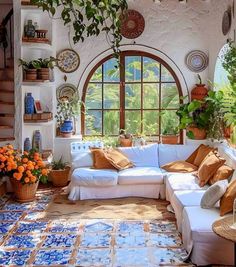 a living room filled with lots of furniture and plants on the wall next to a window