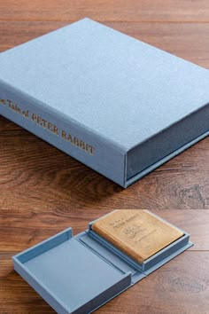 a book sitting on top of a wooden table next to a small box with a notepad in it