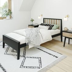 a bed sitting on top of a wooden floor next to a white and black rug