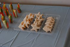 several trays of food on a table with candy sticks in the shape of christmas trees