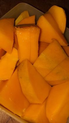 sliced up mangoes in a bowl on a wooden table