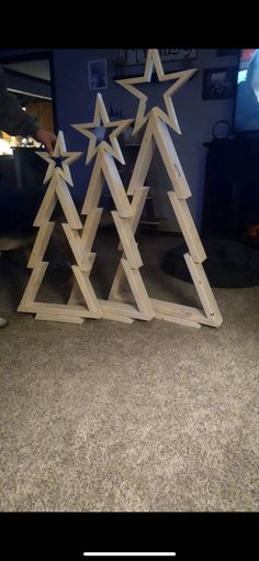 three wooden christmas trees with stars on them